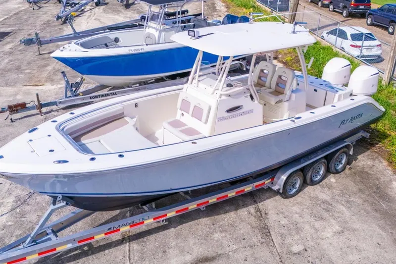 Slide: The Image of 2017 Cobia 296 Center Console boat on trailer, parked outdoors. - 11