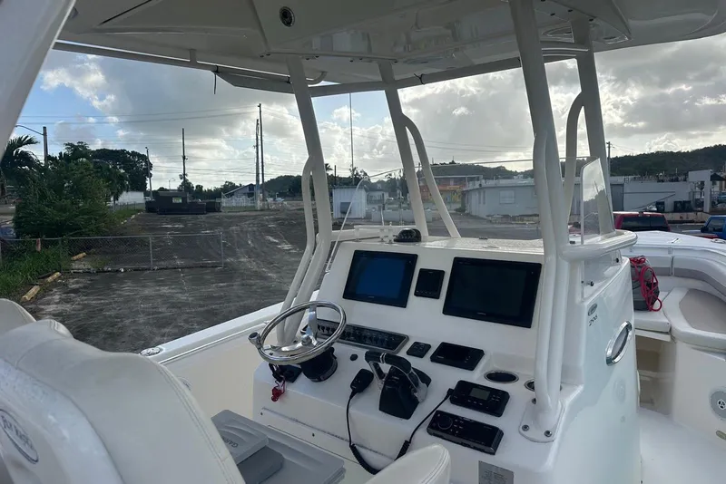 Slide: The Image of 2017 Cobia 296 Center Console boat interior with steering wheel and navigation screens. - 36