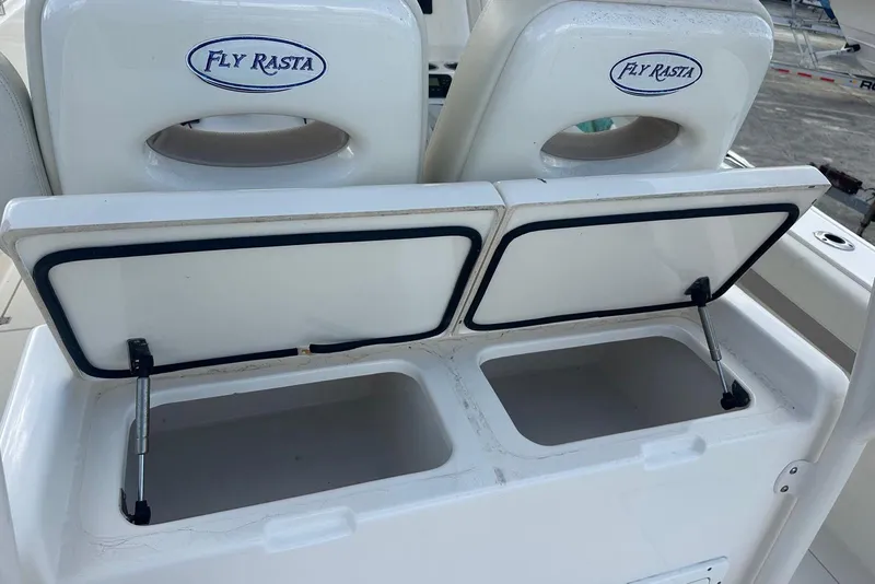 Slide: The Image of 2017 Cobia 296 Center Console boat storage compartments open, labeled "Fly Rasta." - 37