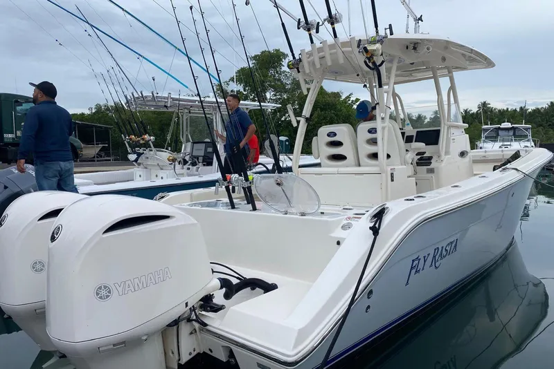 Slide: The Image of 2017 Cobia 296 Center Console boat with Yamaha engines, docked with fishing rods. - 4