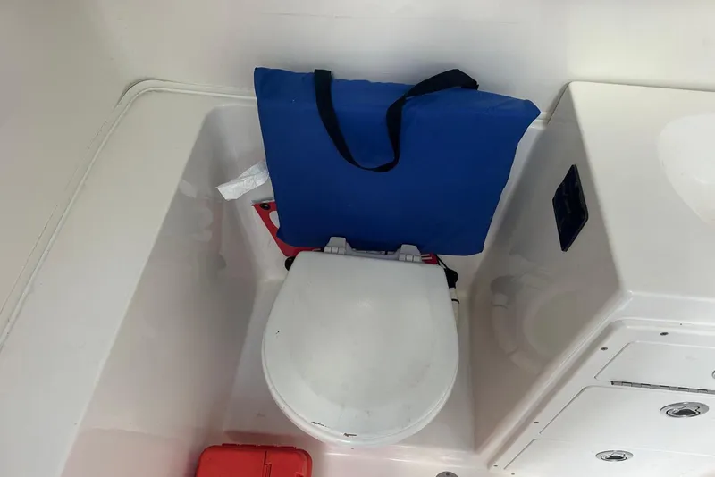 Slide: The Image of 2017 Cobia 296 Center Console boat bathroom with toilet and storage. - 40
