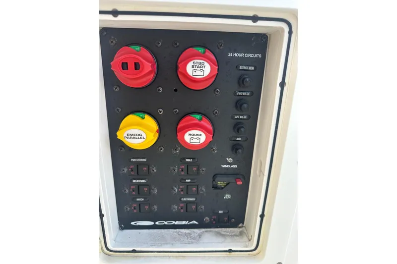 Slide: The Image of Control panel of a 2017 Cobia 296 Center Console boat with switches and circuit breakers. - 43