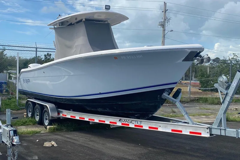 Slide: The Image of 2017 Cobia 296 Center Console boat on trailer, parked outdoors. - 7