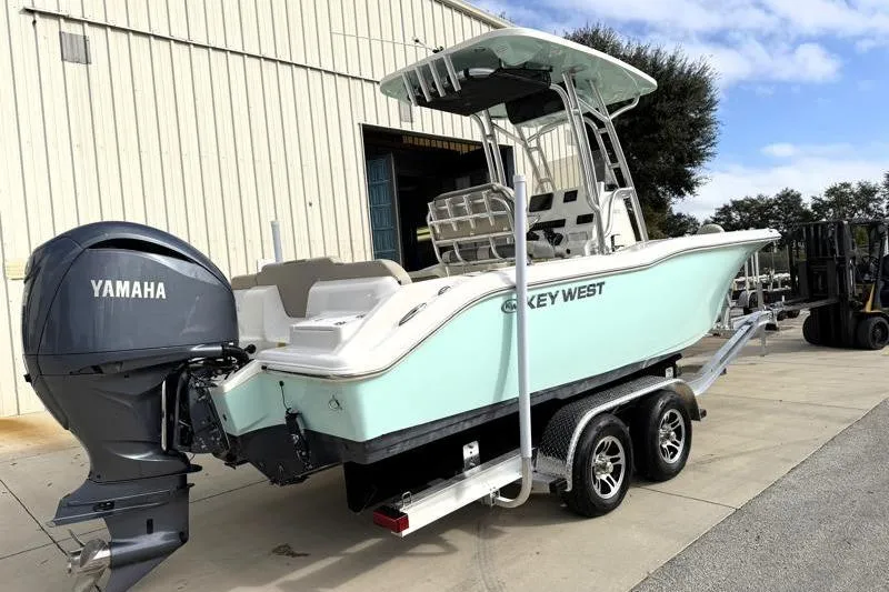 Slide: The Image of 2025 Key West 239 FS boat with Yamaha engine on trailer, parked outdoors. - 2