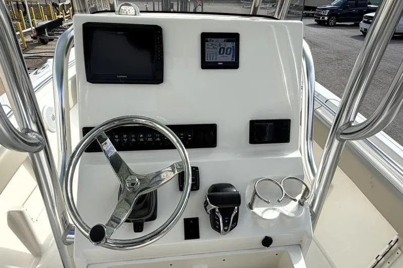 Slide: The Image of 2025 Key West 239 FS boat dashboard with steering wheel, controls, and navigation screens. - 26