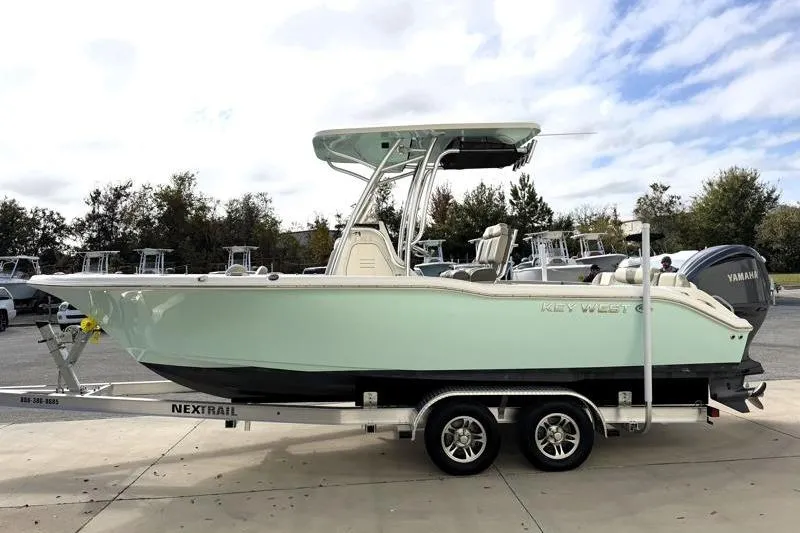 Slide: The Image of 2025 Key West 239 FS boat on trailer, parked outdoors under cloudy sky. - 4