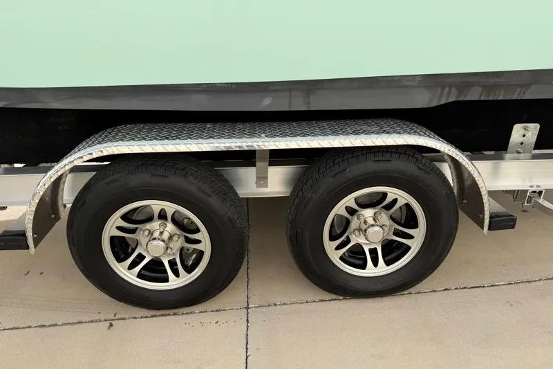 Slide: The Image of Trailer wheels of a 2025 Key West 239 FS boat on pavement. - 44