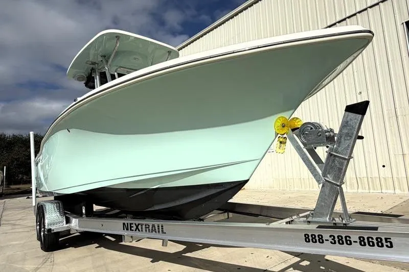 Slide: The Image of 2025 Key West 239 FS boat on trailer, parked outdoors near a building. - 8