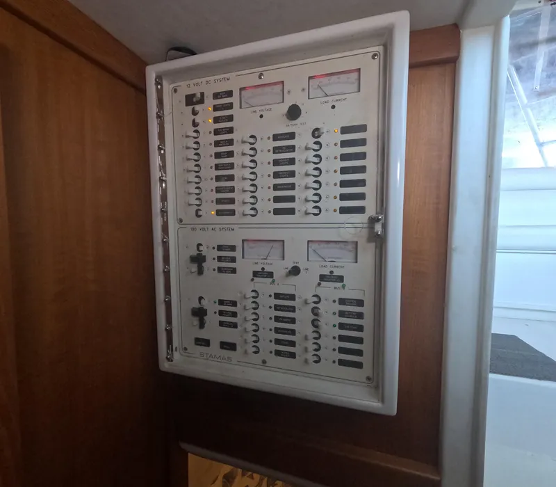 Slide: The Image of Electrical panel inside 2005 Stamas 370 Express boat, featuring switches and meters. - 25