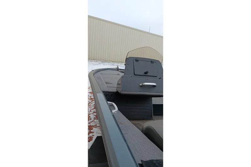 Slide: The Image of 2025 Ranger ALPHA 208 boat interior with console and seating, parked outdoors. - 3