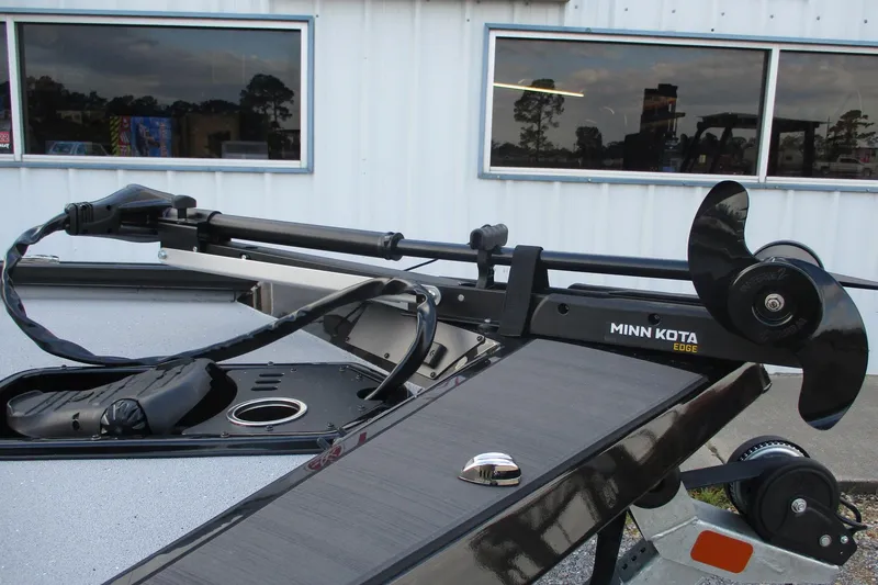 Slide: The Image of 2026 Vexus AVX189 boat with Minn Kota Edge trolling motor, parked outside a building. - 9