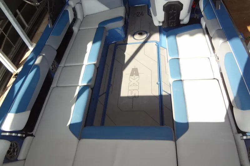 Slide: The Image of 2021 Axis A24 boat interior with blue and white seating, spacious layout. - 14