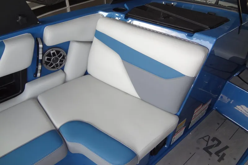Slide: The Image of 2021 Axis A24 boat interior with blue and white seating and speaker. - 15