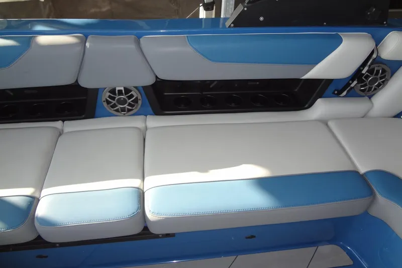 Slide: The Image of 2021 Axis A24 boat interior with blue and white cushioned seating and built-in speakers. - 16