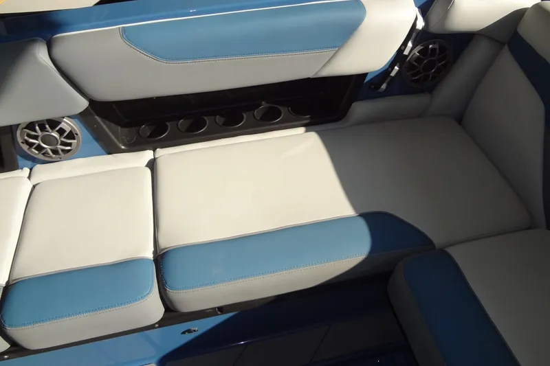 Slide: The Image of 2021 Axis A24 boat interior with blue and white cushioned seating and built-in speakers. - 20