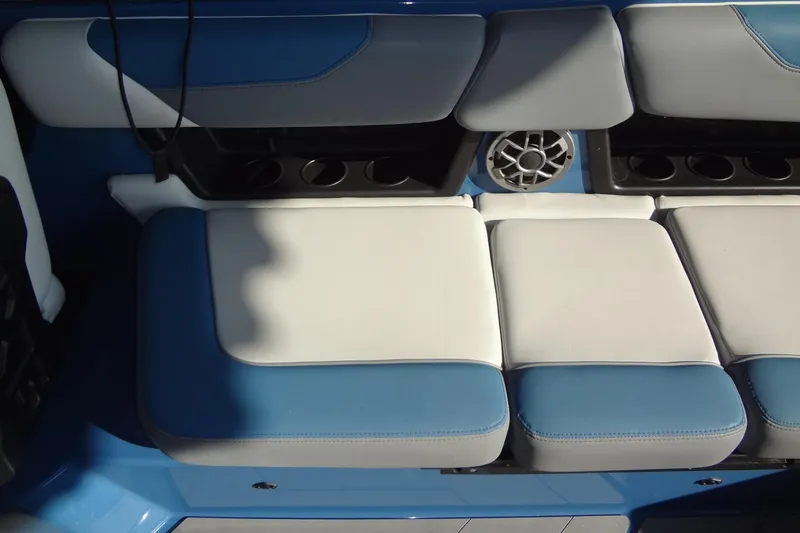 Slide: The Image of 2021 Axis A24 boat interior with blue and white cushioned seating and speaker. - 22