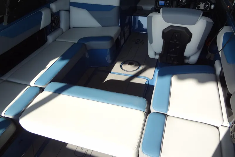 Slide: The Image of 2021 Axis A24 boat interior with blue and white seating, showcasing modern design. - 24