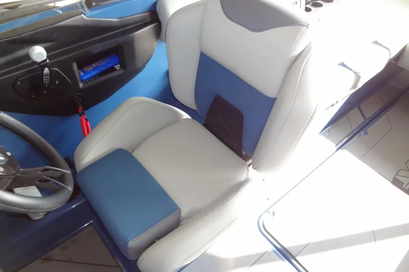 Slide: The Image of 2021 Axis A24 boat interior with blue and gray seating and steering wheel. - 25