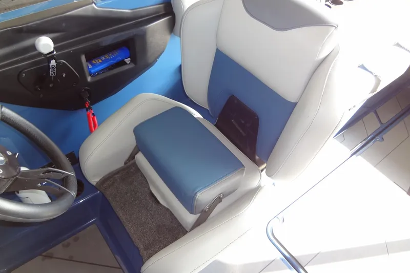 Slide: The Image of 2021 Axis A24 boat interior with blue and white seating and steering wheel. - 26