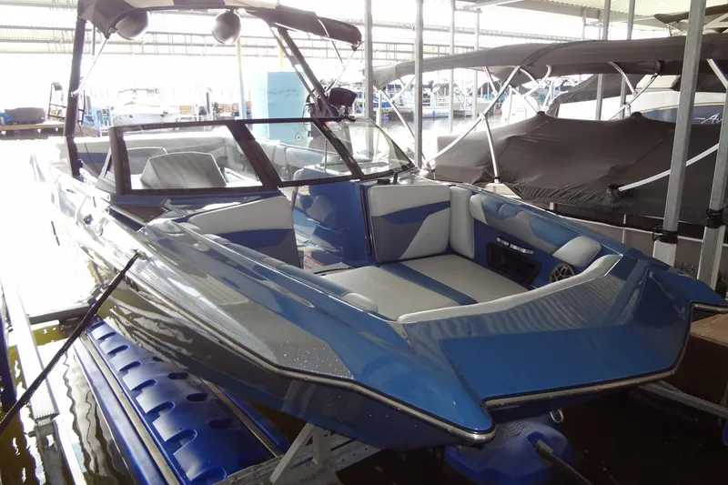 Slide: The Image of 2021 Axis A24 boat in dock, featuring sleek blue and white design. - 4