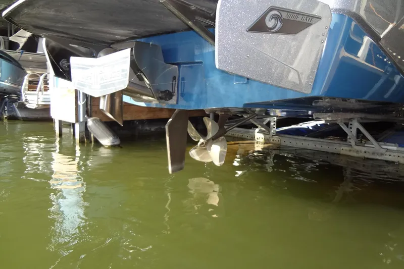 Slide: The Image of 2021 Axis A24 boat propeller and hull in water, showcasing Surf Gate feature. - 56