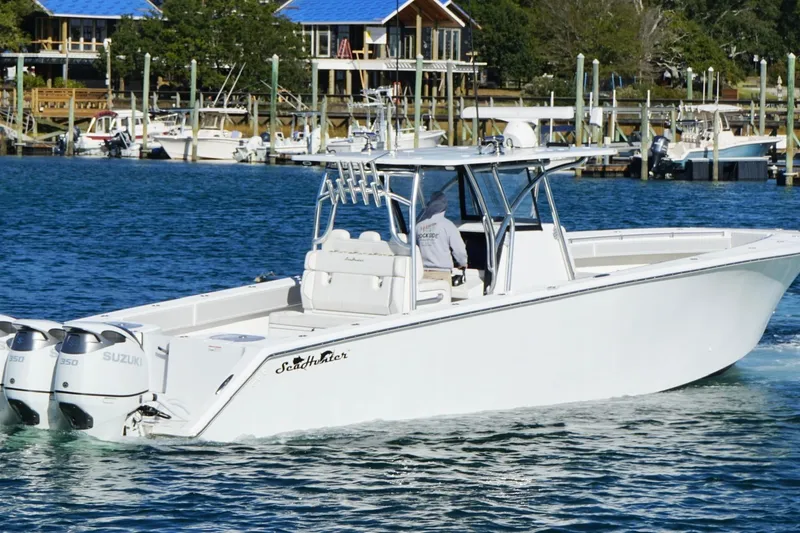 Slide: The Image of 2024 SeaHunter 39 Tournament boat cruising in a marina with twin Suzuki engines. - 10