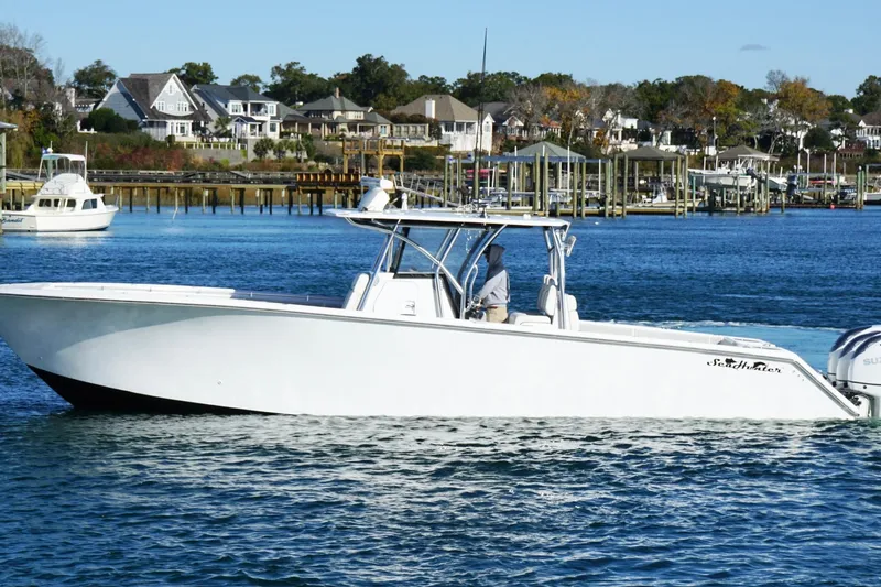 Slide: The Image of 2024 SeaHunter 39 Tournament boat cruising on a scenic waterfront with houses in the background. - 6