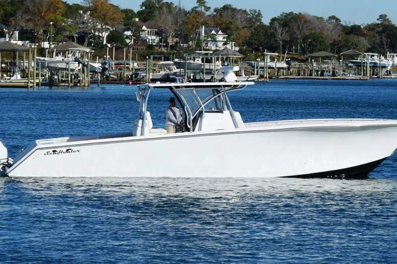 Slide: The Image of 2024 SeaHunter 39 Tournament boat cruising on a calm lake with scenic background. - 9