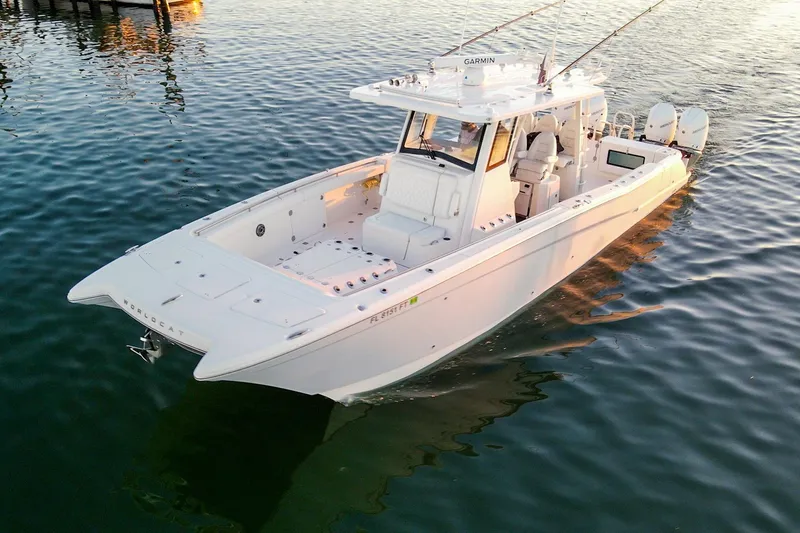 Slide: The Image of 2022 World Cat 400 CC-X boat on calm water, featuring dual engines and spacious deck. - 12