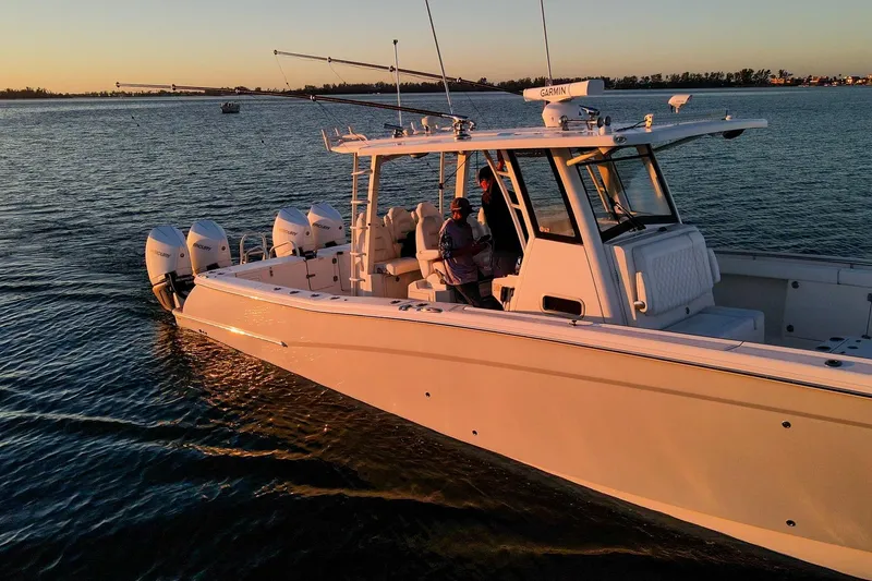 Slide: The Image of 2022 World Cat 400 CC-X boat cruising at sunset with multiple outboard engines. - 4