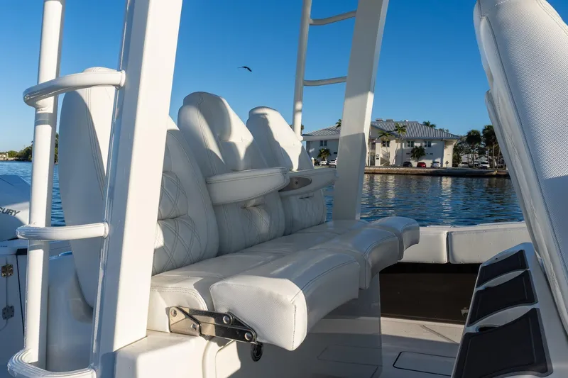 Slide: The Image of 2022 World Cat 400 CC-X boat interior with white seating, near waterfront homes. - 49
