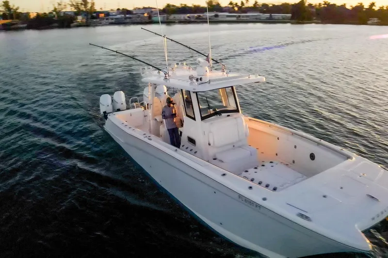 Slide: The Image of 2022 World Cat 400 CC-X boat cruising on calm water at sunset. - 6