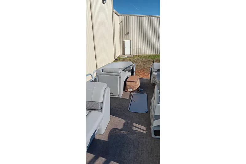 Slide: The Image of 2023 Ranger Reata 223C boat interior with gray seating and storage compartments. - 11