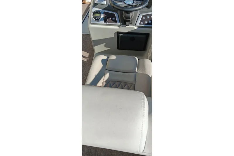 Slide: The Image of 2023 Ranger Reata 223C boat interior with steering wheel and cushioned seating. - 15