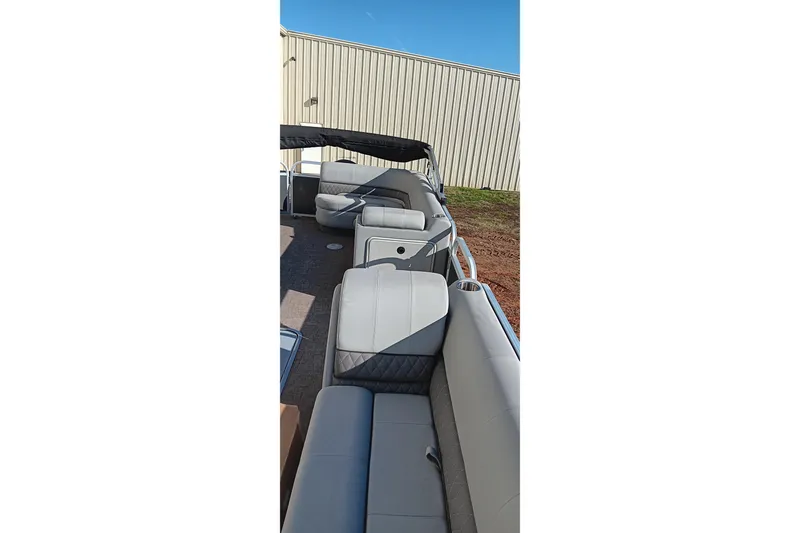 Slide: The Image of 2023 Ranger Reata 223C pontoon boat with spacious seating and canopy, parked outdoors. - 29