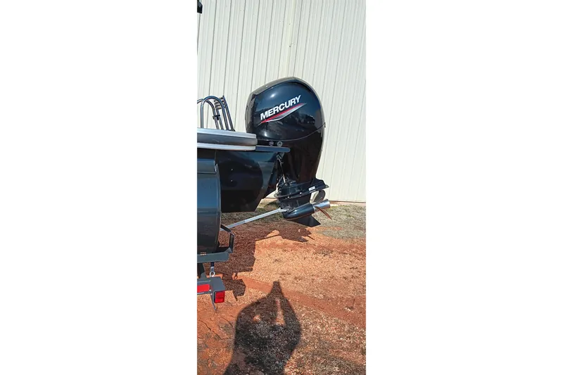 Slide: The Image of 2023 Ranger Reata 223C boat with Mercury outboard motor, parked on red dirt. - 3