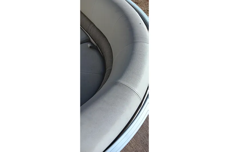 Slide: The Image of 2023 Ranger Reata 223C boat interior with curved, cushioned seating. - 32