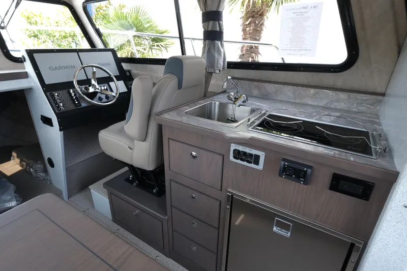 Slide: The Image of Interior of 2026 KingFisher 3025 XRS boat with helm, kitchenette, and modern appliances. - 12