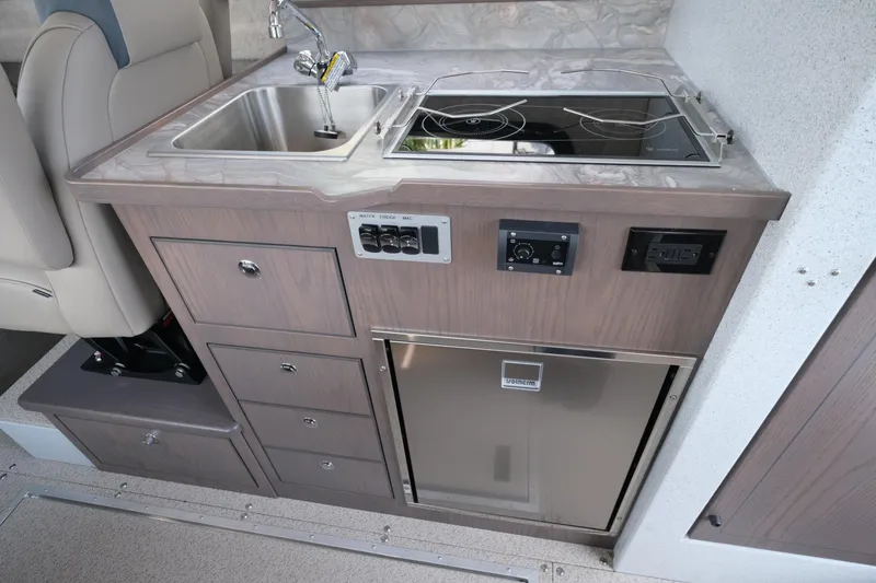 Slide: The Image of Compact kitchen area in 2026 KingFisher 3025 XRS with sink, stove, and storage. - 21