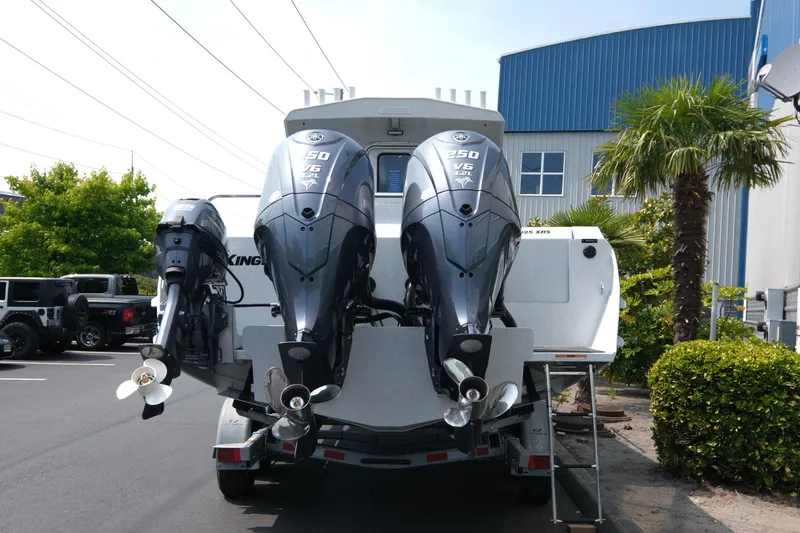 Slide: The Image of 2026 KingFisher 3025 XRS boat with dual outboard engines in a parking lot. - 5