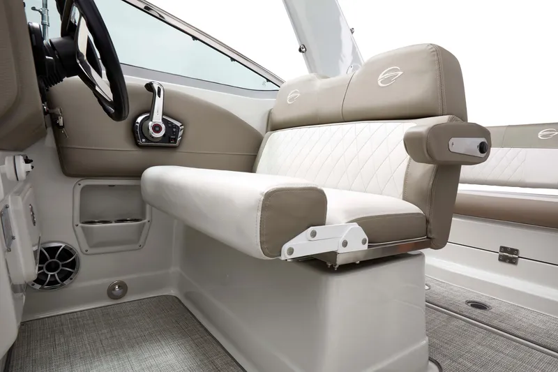 Slide: The Image of 2026 Crownline 270 CR boat interior with beige seating and steering controls. - 10