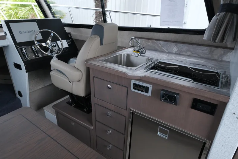 Slide: The Image of Interior of 2026 KingFisher 3025 XRS boat with helm, kitchen sink, and stove. - 11