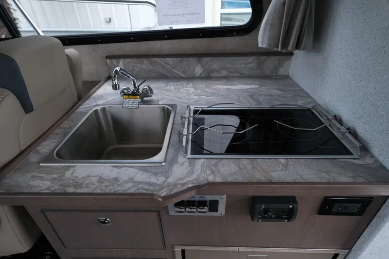 Slide: The Image of Compact kitchen area in 2026 KingFisher 3025 XRS boat with sink and stove. - 22