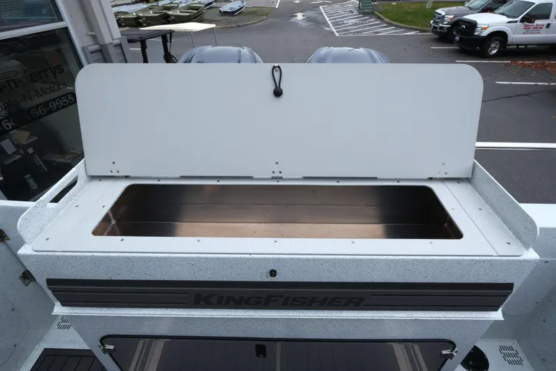 Slide: The Image of 2026 KingFisher 3025 XRS boat with open storage compartment, parked outdoors. - 28