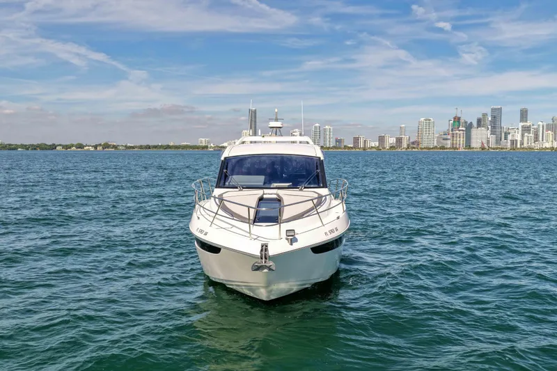 Slide: The Image of 2021 Galeon 425 HTS yacht on water with city skyline in background. - 2