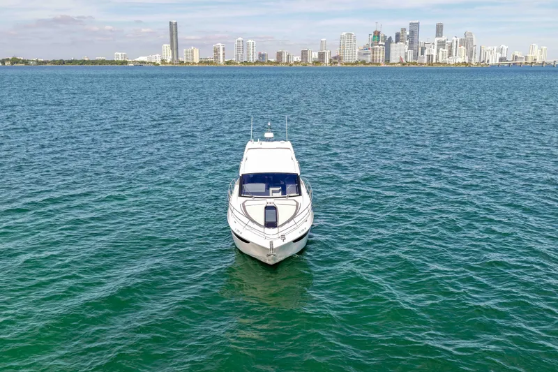 Slide: The Image of 2021 Galeon 425 HTS yacht on open water with city skyline in background. - 5
