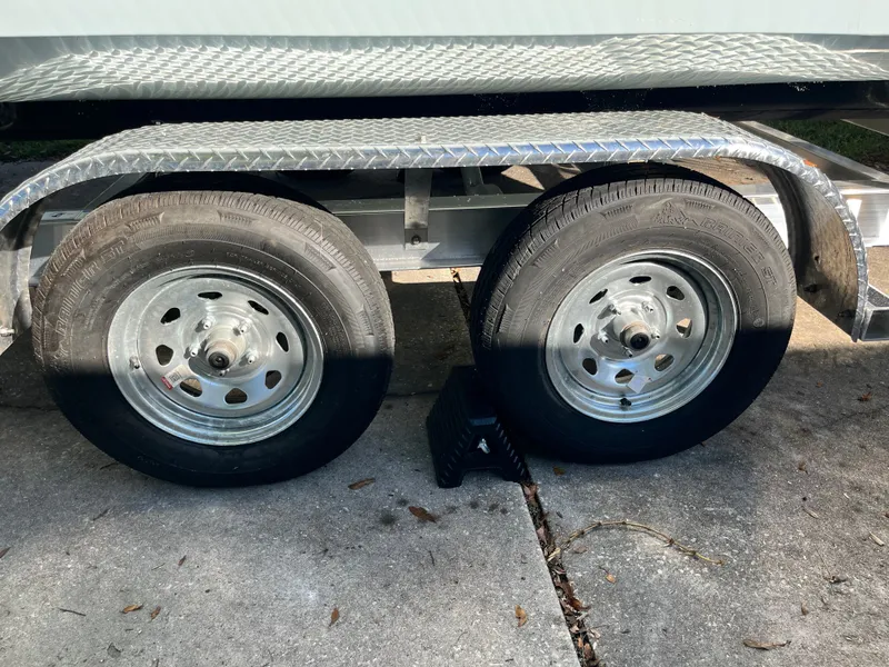 Slide: The Image of Dual trailer wheels of a 2019 World Cat 230 CC boat trailer. - 24
