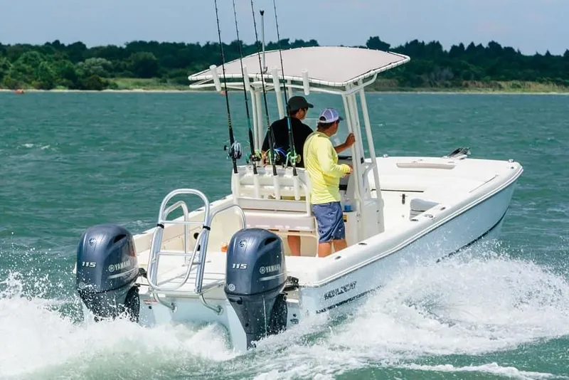 Slide: The Image of 2019 World Cat 230 CC boat on water with two people. - 36