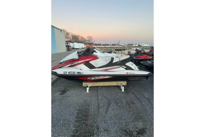 Slide: The Image of 2017 Yamaha WaveRunner FX HO jet ski parked on gravel near a marina at sunset. - 4