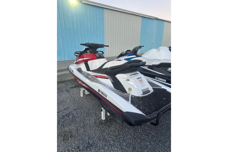 Slide: The Image of 2017 Yamaha WaveRunner FX HO jet ski parked on gravel near a blue building. - 5